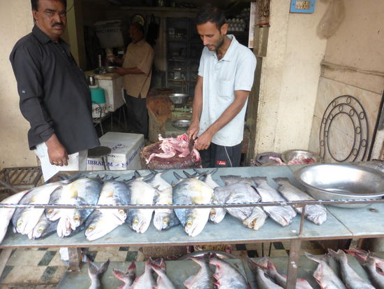 Hier wird gerade ein Huhn zubereitet für das Abendessen der Familie des Mannes im schwarzen Hemd