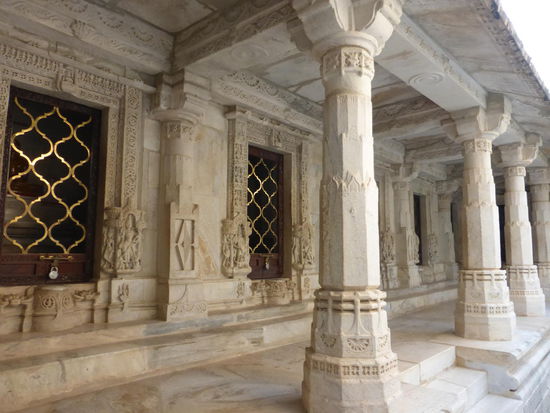 Einige  der 1444 reich verzierten Marmorsäulen im Jain Tempel mit weiteren Götterfiguren in den Räumen hinter den Gittern