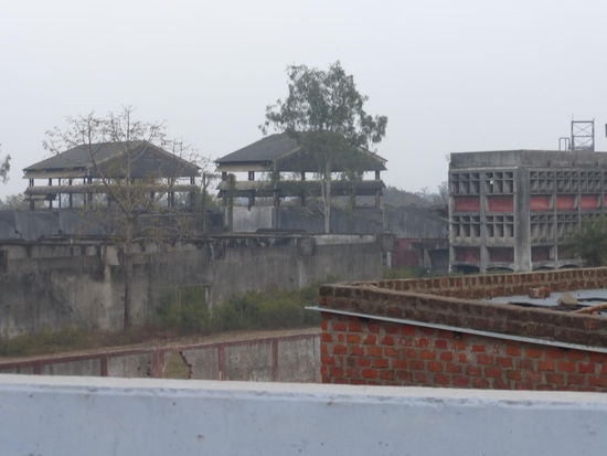 Blick von einer Straßenbrücke auf das Gelände der ehemaligen Union Carbide Fabrik in Bhopal was ansonsten weiträumig abgesperrt ist.