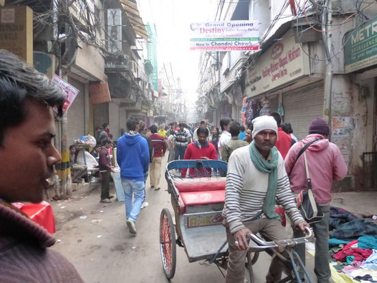 Auch ich lasse mich gerade durch die engen Straßen von Old Delhi fahren mit so einer Fahrrad Rikscha was für mich als etwas beleibter Mensch schon etwas gewöhnungsbedürftig ist. Mein Fahrer rief ständig  Achtung , Achtung hier kommt Germany bitte Platz machen was auch gut funktionierte und unter den meisten Passanten ein kräftiges schmunzeln hervorrief . Der Spaß kostet mich 300 Rupie !!