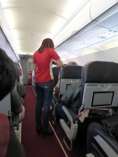 Die Dame verteilt gerade Getränke an Bord von Air Asia