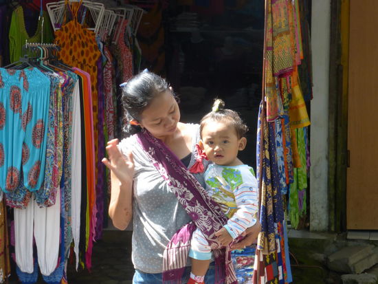 Verkäuferin mit Ihrer Tochter auf dem Arm am Tirta Empul Tempel Bali