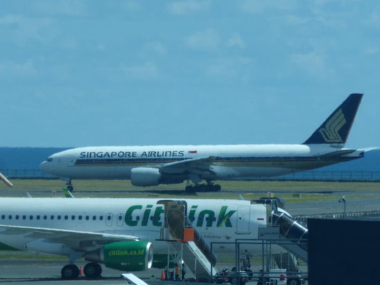 Vorne Maschine der indonesischen Billigairline Citilink und im Hintergrund auf der Startbahn Singapore Airlines
