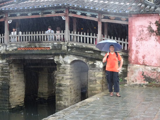Ich vor der japanischen Brücke in Hoi An bei strömenden Regen