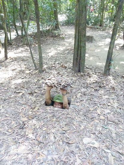 Hier zeigt ein Mitarbeiter des Themenparks wie eng es in den Tunneln ist und wie gut diese getarnt sind