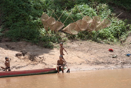Kinder am spielen und Fischfallen im Hintergrund