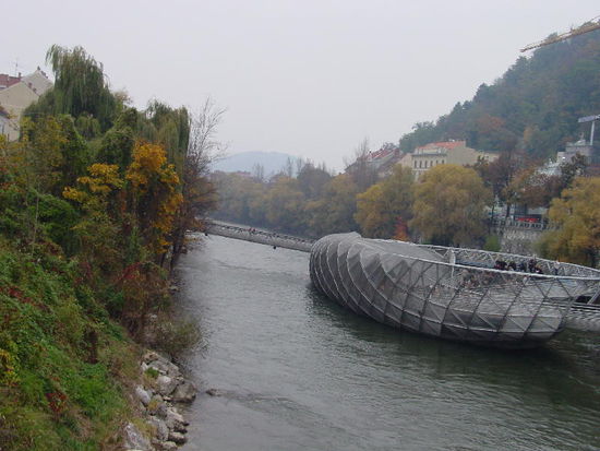 2006 Graz - Insel in der Mur; Wie zwei Schalen einer geöffneten Muschel in Glas und Stahl geschaffen, schwimmt sie mitten in der Mur. Mit Design-Café, Spielplatz und kleinem Amphitheater ist sie beliebter Treffpunkt.