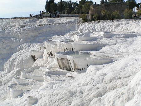 2005 Türkei - Kalkterrassen in Pamukkale; weiss - weshalb? Das warme Wasser (30 - 50 oC) enthält gelöstes Calziumbikarbonat, das beim Abkühlen in Kohlendioxid und Calziumkarbonat (Kreide) zerfällt. Daraus entstanden terassenförmige Becken und tiefe Tröge.