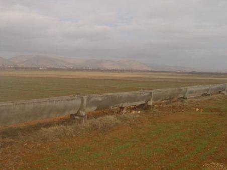 2005 Türkei - flache Ebene in den Bergtälern; im Vordergrund ein Bewässerungskanal, einfach, aber zweckmässig