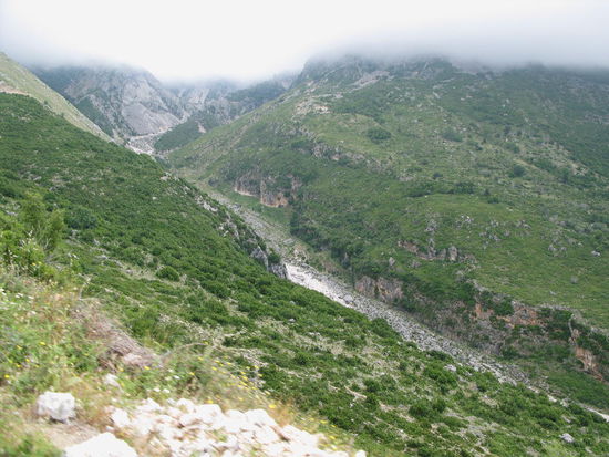 2009 - Llogara-Pass; tiefe Schluchten und geröllführende Bäche. Die Berggipfel sind im Nebel verhüllt. Die Passhöhe liegt auf 1027 m. Das Naturschutzgebiet ist dschungelhaft dicht bewachsen, wird aber touristisch genutzt.