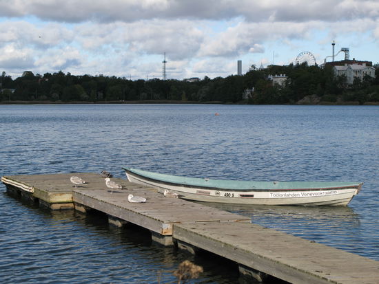 Helsinki - ...direkt an der Töölönlahti-Bucht gelegen ist die Finlandia-Halle; im Hintergrund dreht sich das Riesenrad im Linnanmäki-Vergnügungspark...