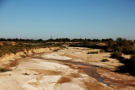 Fast ausgetrocknete Bachbetten...; das Wasser wird für die Bewässerung der Felder abgezweigt...