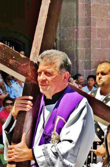 Der Pfarrer persönlich trägt das Kreuz...