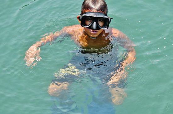 Dieser geschäftstüchtige Junge fordert die Leute auf, Münzen ins Wasser zu werfen...; er taucht nach ihnen und zeigt die Trophäe jeweils mit berechtigtem Stolz...
