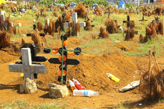 Auf dem Friedhof von San Juan Chamula...; die schwarzen Kreuze zeigen an, dass ein alter Mensch - die weissen ein junger Mensch - verstorben ist...; die Flaschen sind Tranksame in den traditionellen Farben für die Verstorbenen...