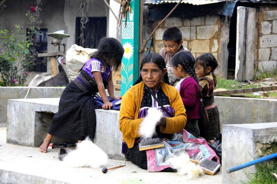 Hier zeigt uns eine Frau, wie sie die Wolle kämmt und nachher zu einem Faden spinnt...