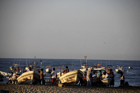 Und trotzdem ist am Strand schon allerhand los...; die Fischer kommen mit ihrem Fang zurück...