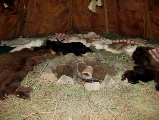 Das Innenleben...; am Boden Tannenreisig, darüber Tierfelle...; fürs Winterquartier wurde innen eine 2. Schicht Birkenrinde aufgezogen, dazwischen eine Isolation aus Moosen und Flechten...; in der Mitte das wärmende Feuer...