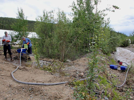 Wir besuchen nebenan Goldwäscher - sie wäscht, er hievt die Kessel auf den Tisch...