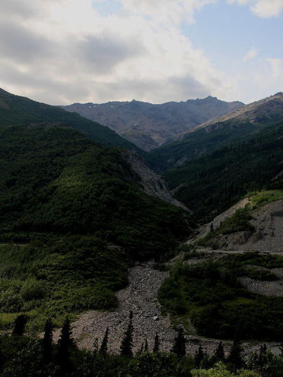 Tiefe furchen im Gebirge...; wir besuchen das Reservationszentrum und müssen zur Kenntnis nehmen, dass heute alles ausgebucht ist...; wir fahren noch weiter zum Reservationsbüro der Parkverwaltung; der Denali NP darf nur auf den ersten 22 Meilen privat befahren werden, es gelten wegen der hohen Besucherzahl - mittlerweile sind es pro Saison über 600'000 - Restriktionen. Man könnte Fahrten mit Bussen in den Park unternehmen - die Preise allerdings sind auch nicht ohne! 
Zudem meldet der Wetterbericht  Regen für die kommenden Tage! Wir verzichten und fahren weiter, haben aber in unserm Reiseführer eine Stelle gefunden von welcher aus man eine ausgezeichnete Sicht auf den Mount Kinley haben soll...!