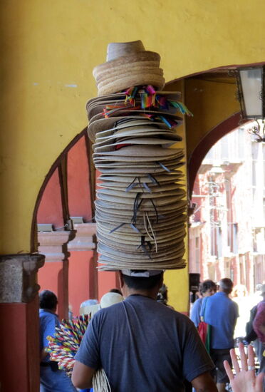Ein Hutverkäufer balanciert sich durch die Touristen