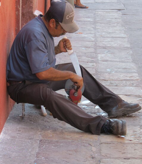Ein Messerschleifer mitten auf dem Gehsteig