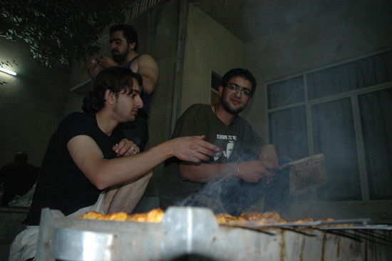 Abed (rechts im Bild) grillt lecker Kebab-Spieße!