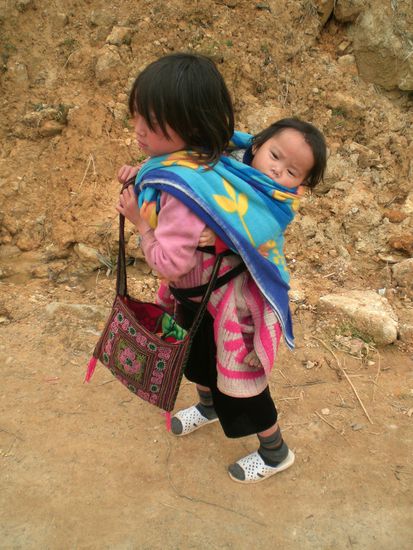 Ein Maedchen traegt ihre Schwester