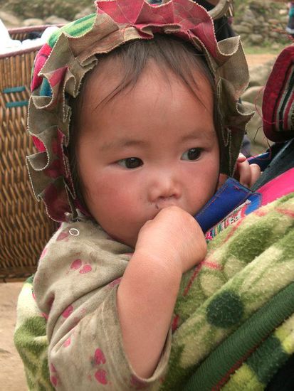 Kind auf dem Ruecken seiner Mutter
