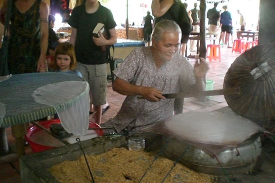 Kambodschanerin beim Reispapier herstellen