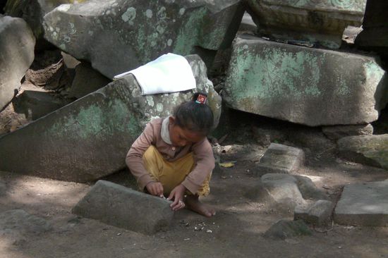 Ein Kind spielt zwischen den rumliegenden Tempelsteinen