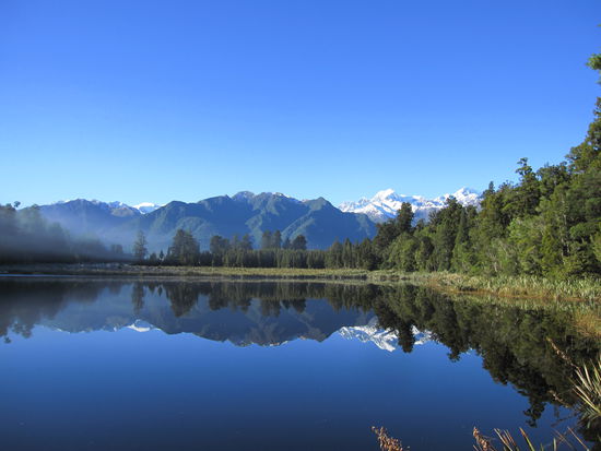wunderschoener Spiegeleffekt des Lake Matheson, der die Berge der Southern Alps spiegelt
