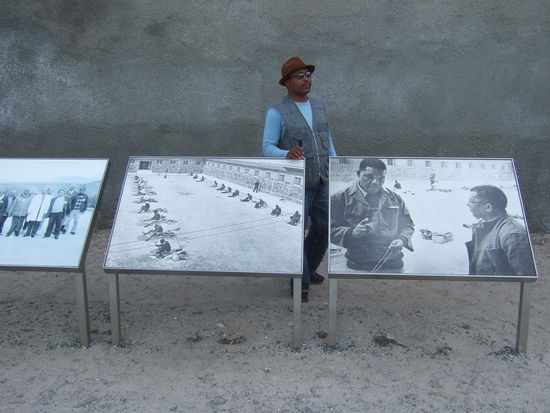 unser Guide, der selbst auf Robben Island im Gefaengnis war, vor einem Foto mit Nelson Mandela