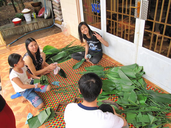Vorbereitungen fuer TET: Zurechtschneiden der Palmenblaetter, die spaeter zusammen gefaltet werden und in die dann Reis gefuellt wird (typische Tradition fuer das vietnamesische Neujahrsfest).