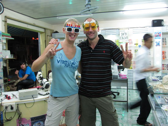 Annette und Michael mit den lustigsten Brillen ueberhaupt: fuer Geburtstagskinder und fuer Biertrinker...wir zeigen hier uebrigens das Peace Zeichen, das alle Asiaten auf Fotos zeigen. Verrueckte Welt!