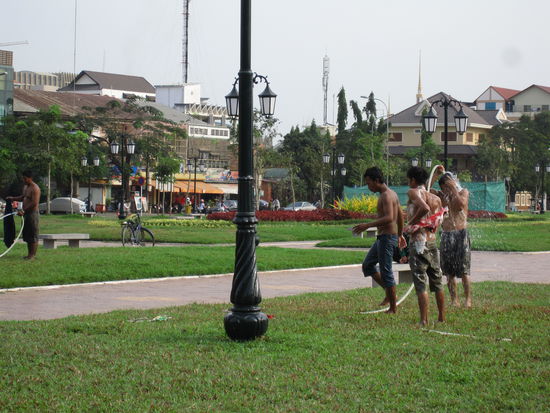Jugendliche nutzen die Wasserschlaeuche, die eigentlich den Rasen bewaessern sollen, zum Duschen.