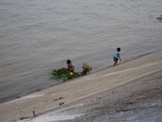 Kinder baden im dreckigen Fluss und versuchen dort etwas essbares zu finden