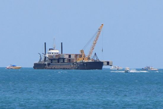 Hier sah es fuer uns so aus, als ob die kleinen Boote die Versenkaktion verhindern wollen und das Frachtschiff mit dem Gueterwagen versucht die Boote zu vertreiben...