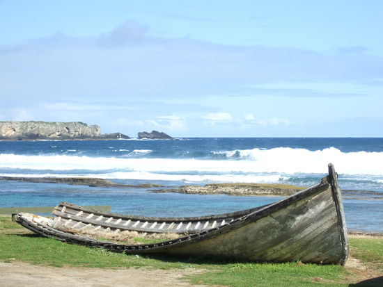 Ein altes Langboot verfaellt am Ufer.
Mit solchen Booten werden nach wie vor saemtliche Gueter von Frachtschiffen, die weiter draussen ankern, an Land gebracht.
Selbst Autos und LKWs!
Dann werden einfach zwei Boote nebeneinander mit langen Blanken verbunden und los geht das Abenteuer.