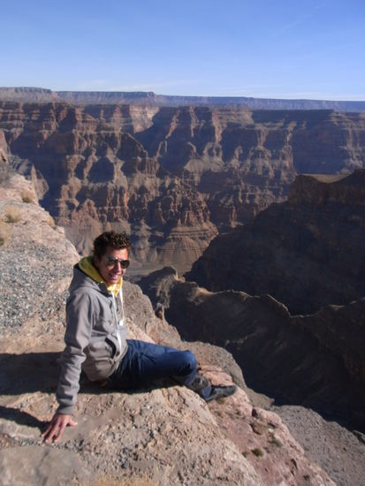 Alex mit seinen Füßen halb-baumelnd über dem Canyon