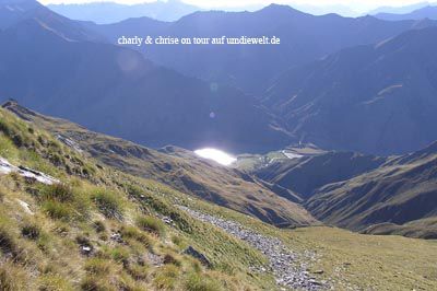 Ein See im Tal unterhalb des BenLomond, in dem sich die Sonne spiegelt.