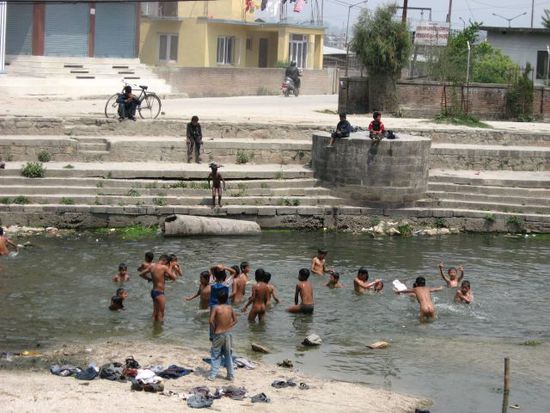 Baden im heiligen, dreckigen Bagmati-Fluss (hier gottseidank stromaufwaerts von den Leichenverbrennungen)