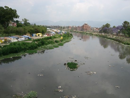 der stark verdreckte Bagmati-Fluss, der Kathmandu und Patan trennt, und links ein Slum