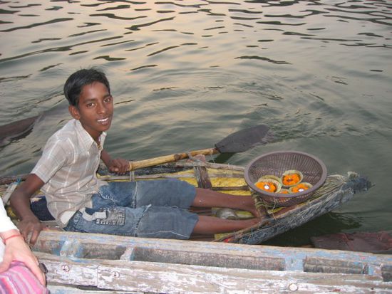 Junge beim Verkauf von schwimmenden Kerzen für die Puja