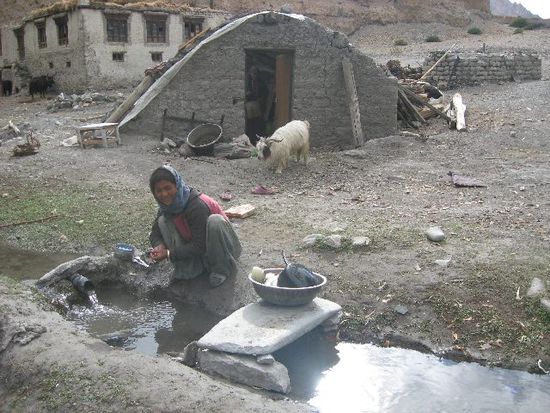 Hier im eiskalten Wasser wird das Geschirr abgewaschen, natürlich ohne Spülmittel. Mittig im Hintergrund ein Foliengewächshaus.