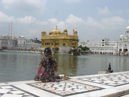 im Hintergrund links die lange Menschenschlange, die in den Goldenen Tempel hinein will