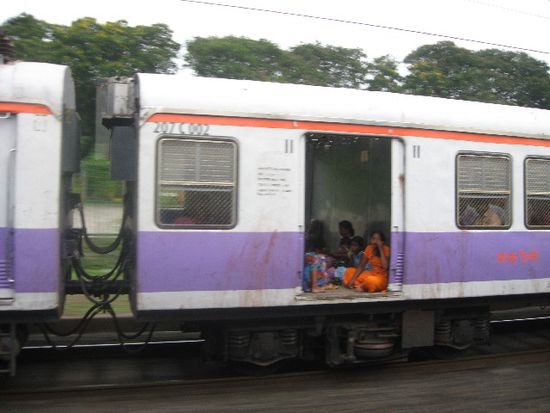 Local Train in Mumbai - hier ausnahmsweise nicht überfüllt, oft aber gerammelt voll, und zwar so sehr, dass die Leute noch draußen drauf hängen