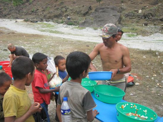 der Rest des von uns uebrig gelassenen Essens geht in die Plastiksaecke der hungrigen, geduldig wartenden Kinder
