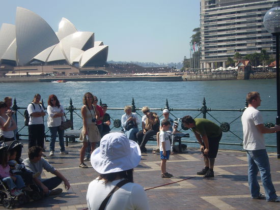 Einer der vielen Strassenentertainer (im gruenen T-Shirt), der versucht einen kleinen Jungen (der fast der kleine Veit sein koennte, oder? ) in sein Programm einzubinden! Und was ist das da im Hintergrund?