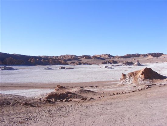 Ueberall sind Salzkristalle, die die Landschaft weiss faerben und in der Sonne glitzern.